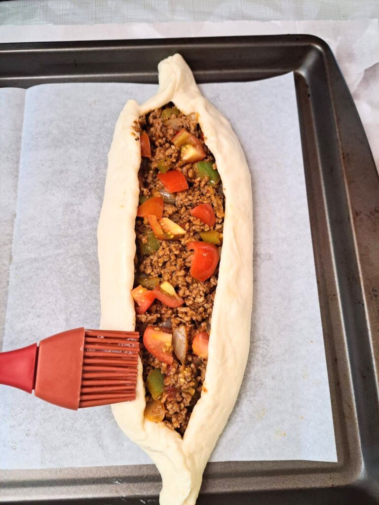  Brush the sides of Turkish Pide with egg wash